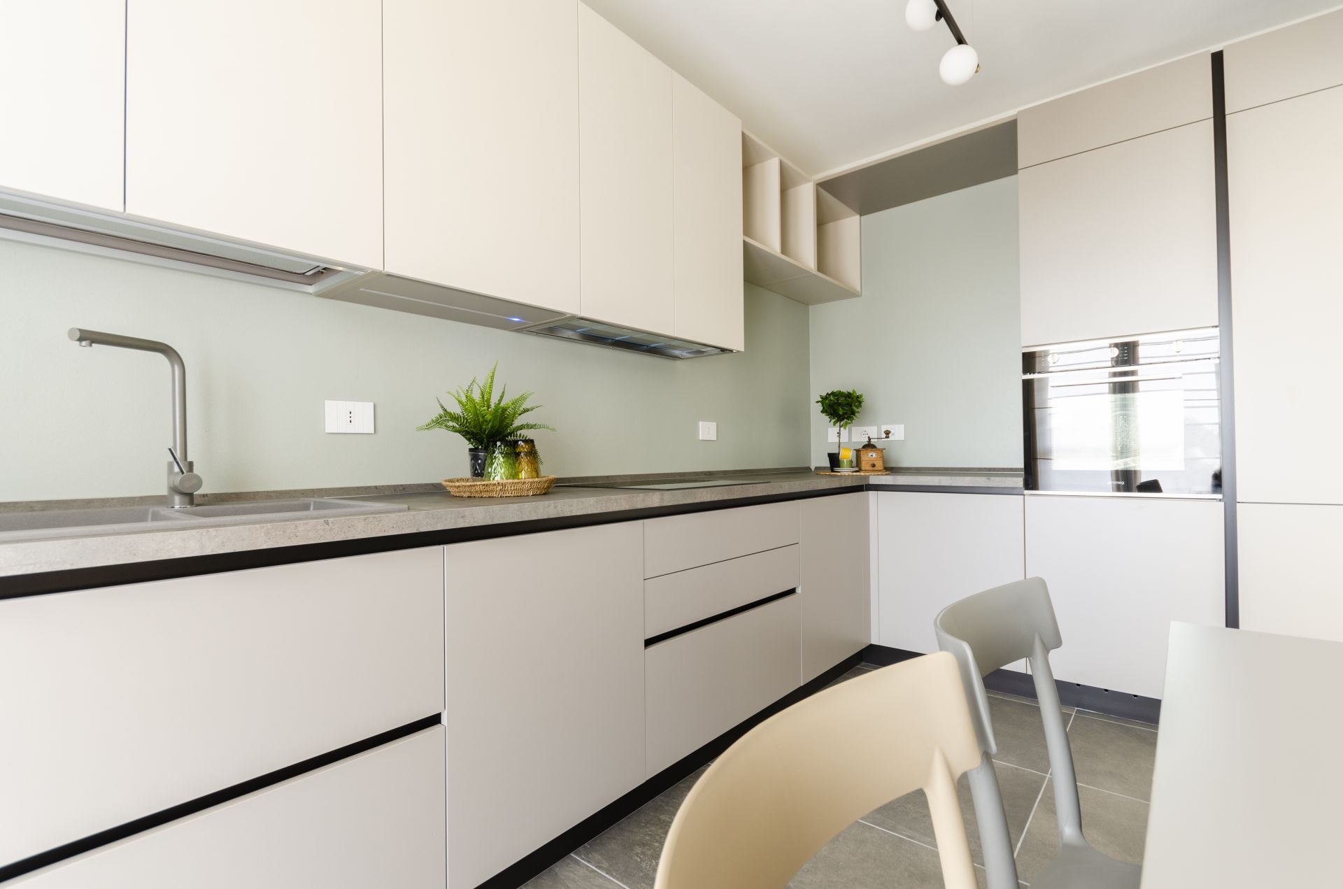 Una cucina moderna e funzionale con doppia colonna e tavolo da pranzo realizzato da Gilardi Interiors on Staging, Progettazione di interni a Melzo